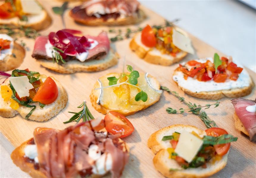 A selection of small appetizers or hors d'oeuvres on toasted bread.