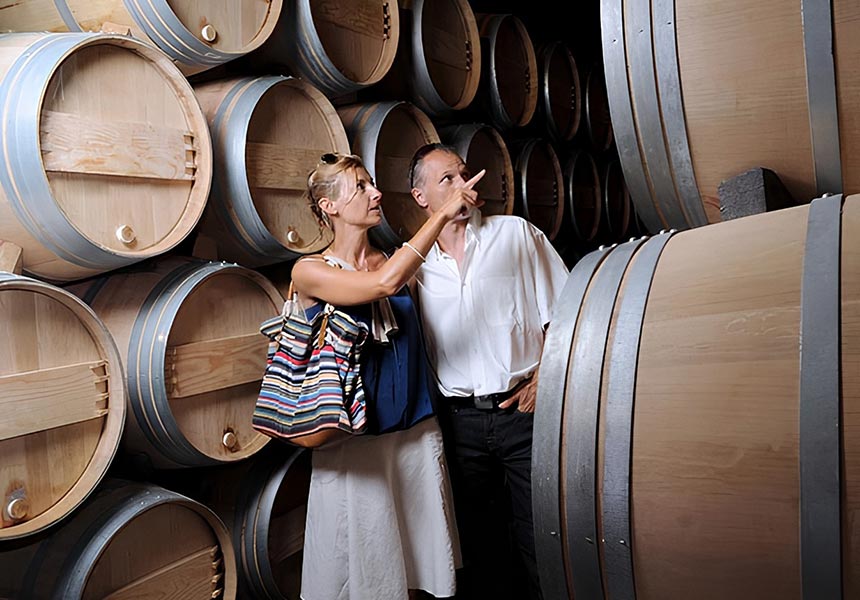 Couple looking at wine barrels.