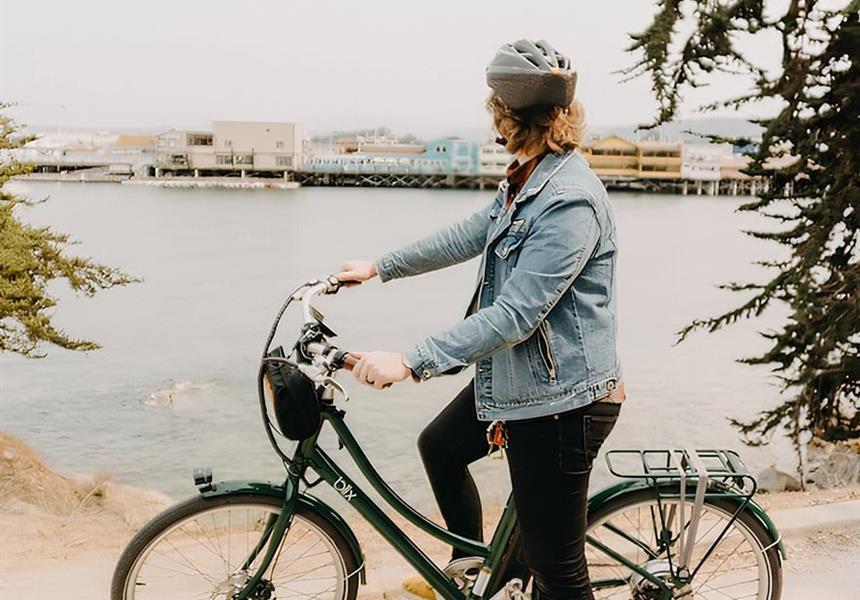 Person using the bike rental to ride the trail by the harbor.