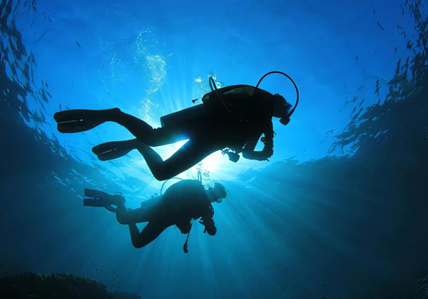 Two people scuba diving in Monterey.