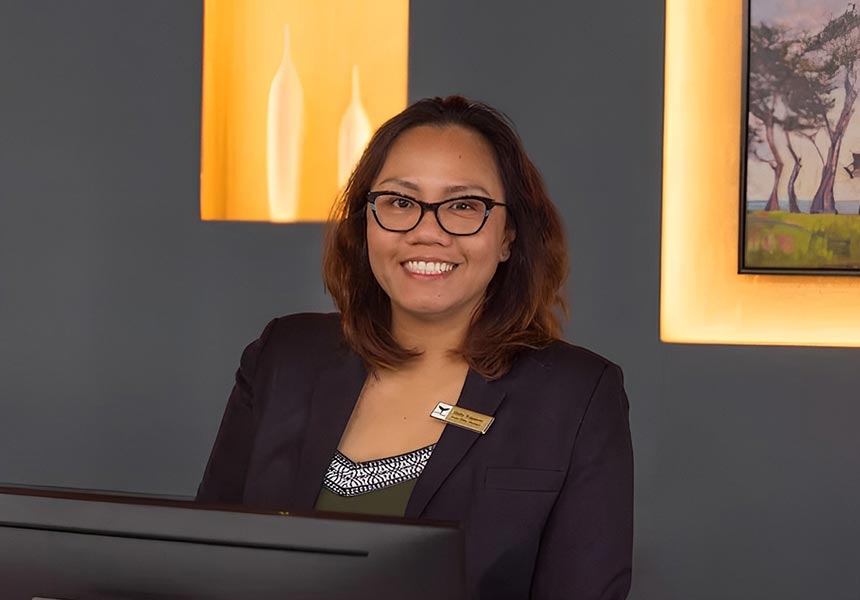 Front desk employee smiling.