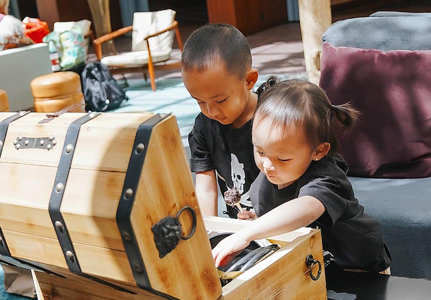 Two kids with a pirate treasure chest. 