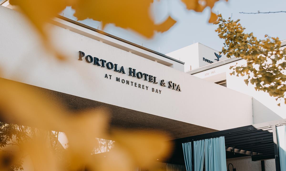 Front view of the Portola Hotel & Spa peeking through leaves.