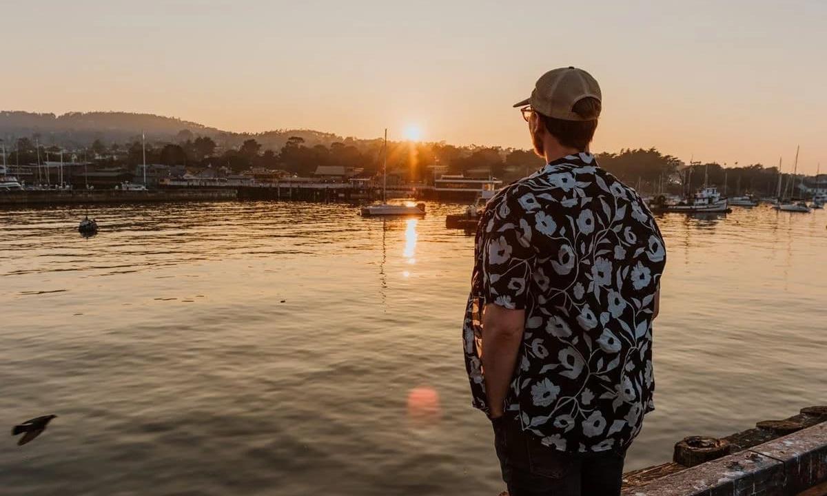 Man looking at a sunset in the harbor