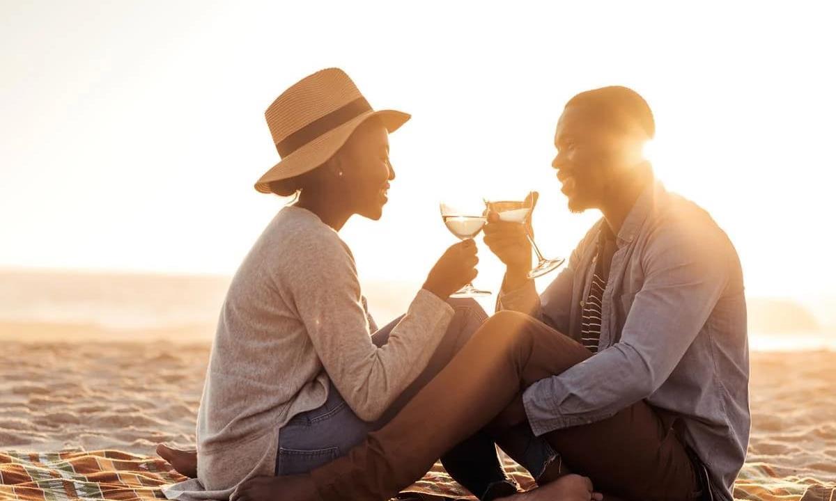 couple on the beach drinking