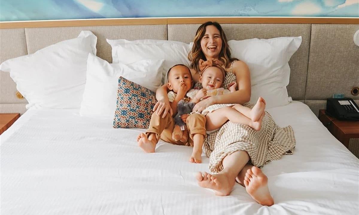 family laughing in hotel bed