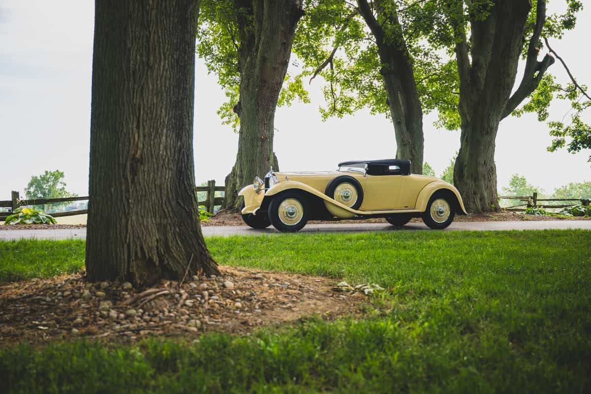 classic roadster car on gravel road
