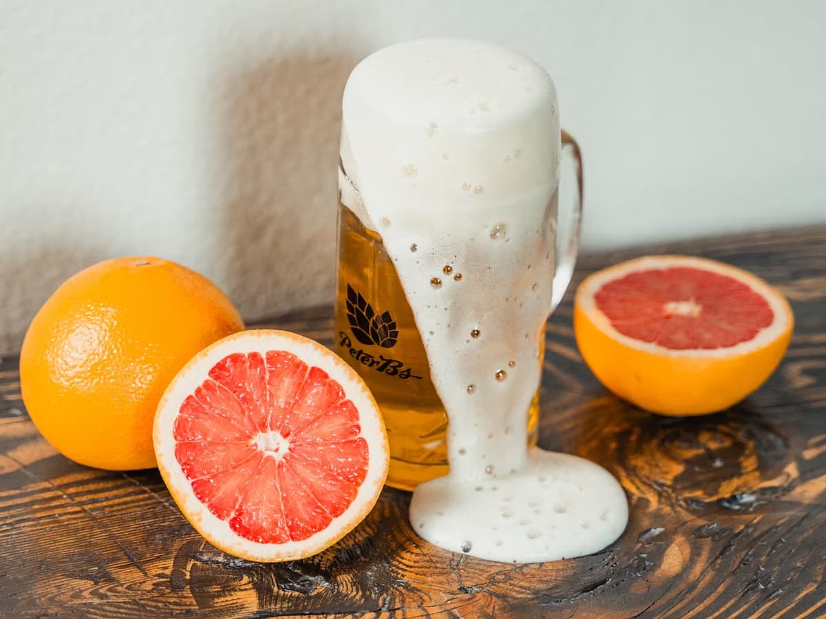 a pint of beer with grapefruit surrounding it