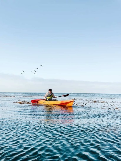 person kayaking off the coastline