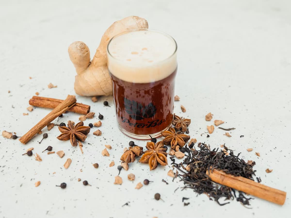 a pint of beer with spices surrounding it