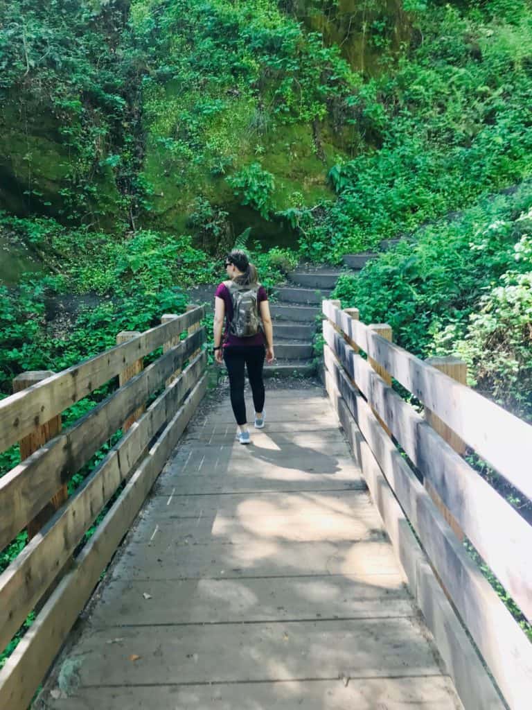 woman on a hike crossing a bridge