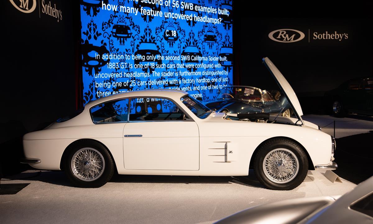 White SWB California Spider luxury car on display on a stage