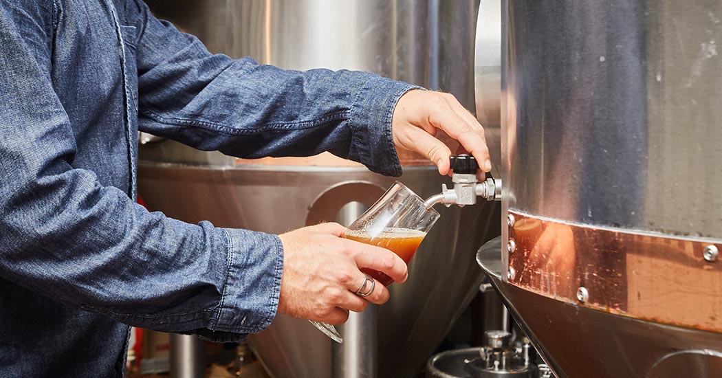 Brewer pouring beer. 