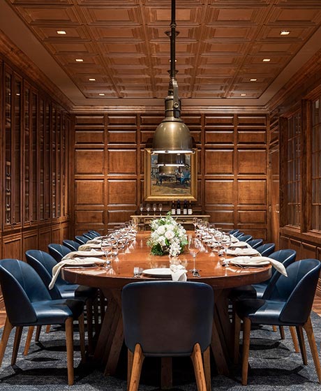 Long conference table with leather seating and detailed woodwork paneling