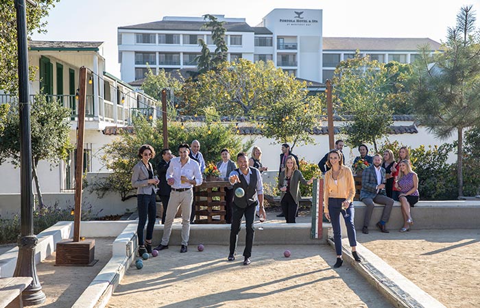 A group of people using the bocce court. 