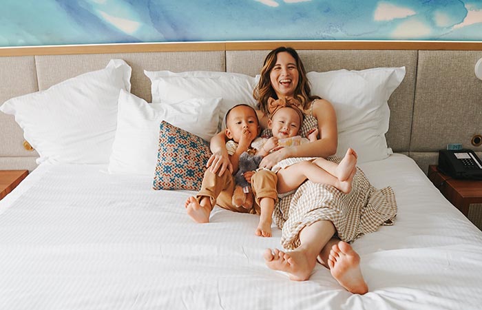 Family laughing together on a guest bed.
